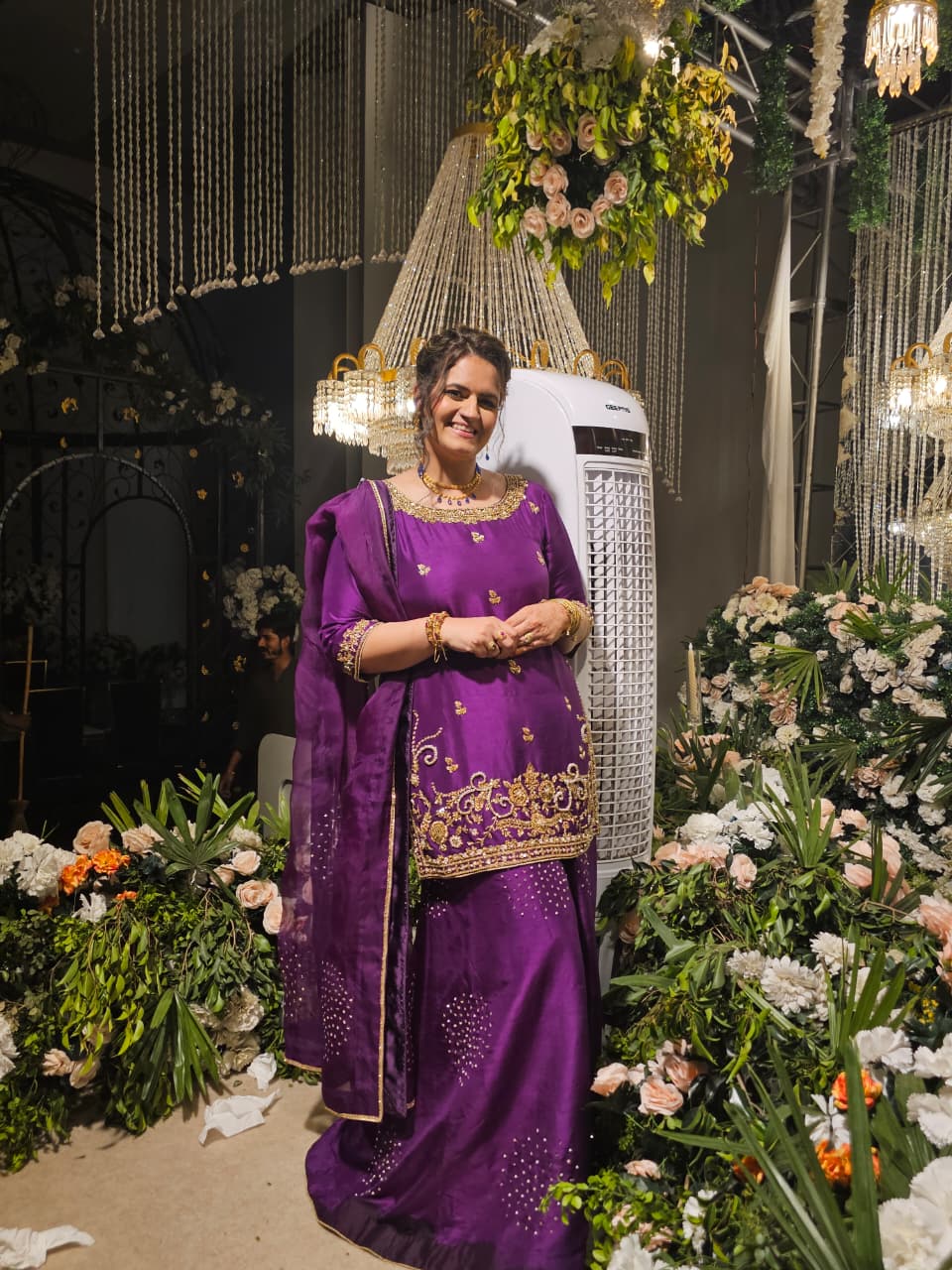 Real client in purple silk kameez with gold embroidery at a wedding venue